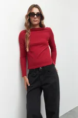 Remera negra de manga larga, cuello alto y corte diagonal en la parte inferior.