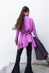 Camisa manga larga color beige con textura plumetie, abotonada en el pecho y lazo regulable que permite múltiples usos.