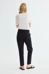 Pantalón cigarette azul marino de tejido elástico, con cintura estándar, bolsillos al bies y perneras ajustadas con raya marcada.