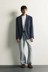 Blazer regular fit azul marino confeccionado en tejido con elasticidad, con cuello de solapas de muesca, cierre frontal con botones y bolsillos con solapa en la cadera.