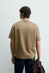 Camiseta de corte relajado con cuello redondo y manga corta, confeccionada en tejido de algodón liso.