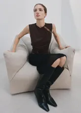 Musculosa marrón de cuello redondo y corte ajustado, con detalles de encaje transparente en el hombro derecho y en el lateral izquierdo.