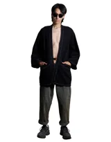 Kimono de denim negro lavado, de manga corta ancha y corte recto. Se cierra al frente con un broche metálico rectangular.