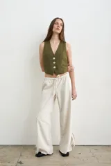 Pantalón recto de lino y algodón color crudo, con cintura elástica con cordón ajustable y tiras regulables en los tobillos.