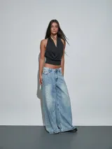 Top negro de diseño cruzado en el frente, con cuello halter y espalda descubierta.