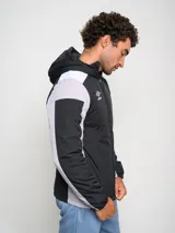 Campera deportiva Umbro con capucha, cierre frontal y bloques de color. El cuerpo principal es azul marino, los hombros son blancos y las mangas tienen paneles laterales en gris claro.