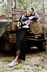 Sweater tejido a mano con diseño de rombos en blanco y negro con flores bordadas.