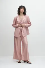 Blazer oversize de lino color rosa metalizado, con solapas de muesca, cierre con doble botonadura y bolsillos delanteros con solapa.