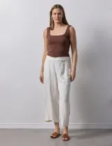 Pantalón de lino color crudo, de corte ancho y largo cropped, con bolsillos laterales.