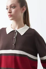 Sweater de tejido de punto con diseño a rayas horizontales en tonos marrón, rojo y crema. Presenta cuello tipo polo con cierre frontal de botones y mangas largas con puños ajustados.