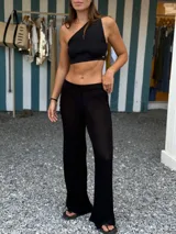 Pantalón negro de tejido de punto con entrelazado en los laterales.