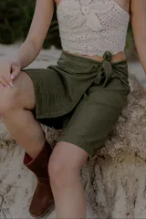 Pollera marrón de corte midi, con diseño cruzado y lazo lateral.