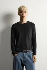 Camiseta de manga larga con cuello redondo, confeccionada en tejido con estructura de canalé y corte relajado.