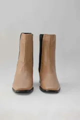 Botas de cuero color beige con elásticos laterales negros, taco cuadrado y punta cuadrada.