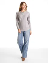 Buzo de tejido fino con escote henley y cierre de botones. Presenta detalles acanalados en hombros, puños y ruedo, con una silueta cómoda y terminación redondeada en la parte inferior.