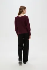 Sweater de punto color bordó, con cuello a la base, mangas largas con puños ajustados y diseño holgado.