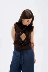 Chaleco de punto sin mangas con cuello polo, diseño de rombos estilo argyle en tonos marrón, negro y beige.