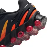 Championes Nike Air Max Dn8 de diseño deportivo, color negro con detalles degradados en naranja y suela con cápsulas de aire rojas.