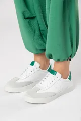 Zapatillas acordonadas de cuero color blanco con puntera de gamuza gris y detalles en verde.
