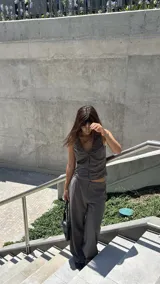 Pantalón de corte recto y tiro medio, confeccionado en tejido crepé con diseño de raya diplomática. Presenta una caída fluida, bolsillos laterales y cierre frontal.