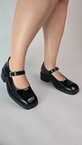 Zapatos tipo Mary Jane de cuero legítimo color negro, con acabado charol, puntera cuadrada, taco bajo de 4.5 cm y tira con hebilla en el empeine.