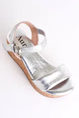 Sandalia plateada con plataforma de corcho, diseño cruzado y tira con hebilla al tobillo.