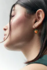 Aros colgantes con dije de vidrio naranja con forma de flor y herraje dorado.