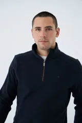 Buzo de hombre color bordó, con medio cierre frontal, cuello alto y logo estampado en el pecho. De corte regular y manga larga.