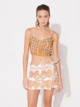 Top corto de lino color beige con estampado de palmeras en color naranja. Tiene breteles finos regulables y doble forro.