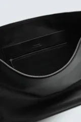 Bolso de hombro de diseño minimalista confeccionado en piel de alta calidad. Cuenta con un compartimento principal con cierre de cremallera, interior con bolsillos organizadores y asa de hombro fija. Incluye un detalle de llavero colgante.