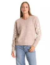 Buzo de punto marca Pinch, color marrón claro, con cuello redondo y mangas largas. Presenta un diseño de flores blancas bordadas a lo largo de las mangas y detalle de frunce en los hombros. Cuenta con puños y ruedo acanalados.