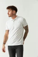 Remera polo blanca de manga corta, con cuello clásico, cierre de tres botones y logo estampado en el pecho.