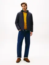 Campera ligera azul marino con cuello alto y cierre frontal de cremallera. Presenta un pequeño logo bordado de Tommy Hilfiger en el pecho.