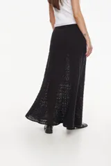 Falda larga de tejido artesanal negro, con diseño fluido y detalles calados.