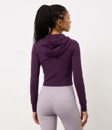 Campera deportiva de microfibra color violeta oscuro, con capucha ajustable por cordón, cierre frontal completo y mangas largas con puños con abertura para pulgar.