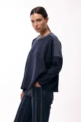 Remera de silueta relajada, confeccionada en tejido de punto, con cuello redondo, mangas largas y un bolsillo aplicado en el frente.