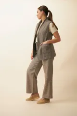 Chaleco color crema con solapas, corte entallado y bolsillos plaqué.