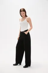 Pantalon jean de corte barrel y tiro medio, en color negro, con diseño de pierna ancha y estructura rígida.