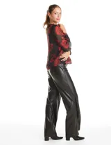 Blusa de gasa con estampado floral en tonos rojos sobre fondo negro. Presenta escote en V, mangas largas traslúcidas con puños ajustados y detalles de fruncido en los hombros.