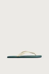 Sandalias de dedo fabricadas en goma, con suela plana verde oscuro y tiras en el empeine de color blanco.