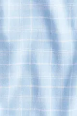 Pantalón de franela de algodón suave, color celeste con estampado a cuadros blancos. Tiene cintura elástica con cordón ajustable y bolsillos al bies. Corte relajado.