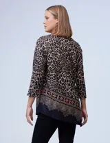 Buzo de tejido soft estampado animal print en tonos blanco, negro y gris, con ruedo asimétrico y mangas tres cuartos.