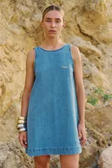 Vestido corto de denim celeste, con escote redondo, espalda descubierta y logo bordado en el frente.