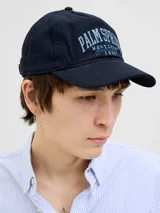 Gorra de béisbol azul marino con bordado frontal de la inscripción "Palm Spring West Coast Jack & Jones 1990" en color celeste.