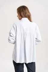 Camisa de pana blanca con cuello clásico, cierre frontal de botones y aplicaciones florales en relieve en el frente.