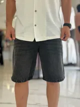 Bermuda de jean de corte oversize, en color negro con efecto gastado.