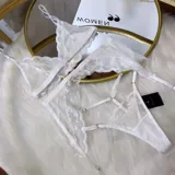 Set de lencería de cuatro piezas compuesto por bralette de encaje, tanga regulable, portaligas y ligas. Confeccionado en microtul y encaje con transparencias.