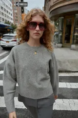 Jersey de punto color vino tinto, de cuello redondo y manga larga, con acabado acanalado (rib) en puños, cuello y bajo.