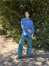 Pantalón de gabardina color crudo con estampado artístico de motivos botánicos y arquitectónicos. Presenta corte recto, tiro medio y bolsillos laterales.