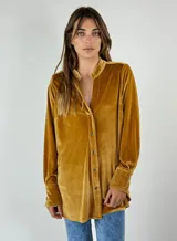 Camisa amplia de terciopelo color mostaza, con cuello mao y cierre frontal con botones.